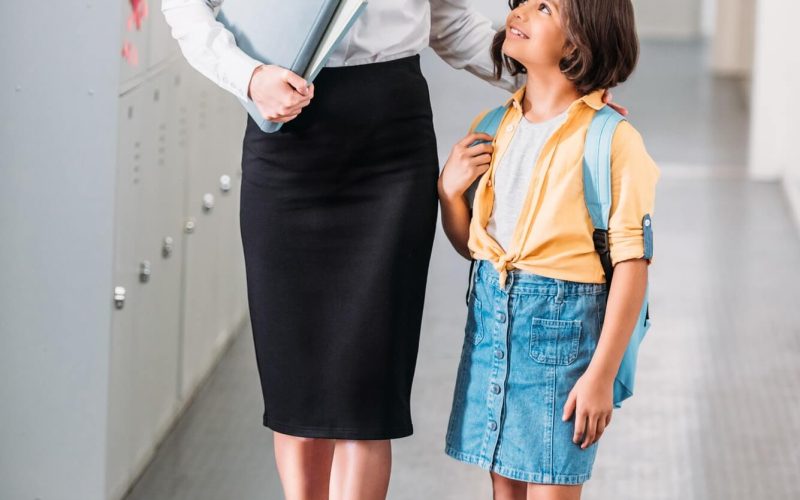 teacher-and-schoolgirl-walking-together-by-school-corridor-1.jpg